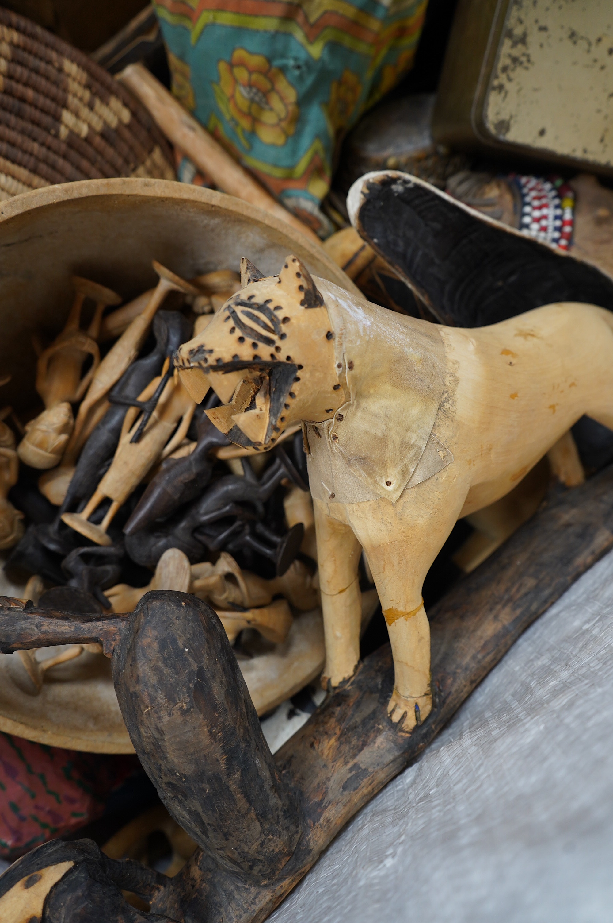 A quantity of African and Asian tribal carvings, basket woven dishes etc., largest dish 50cm diameter. Condition - poor to fair